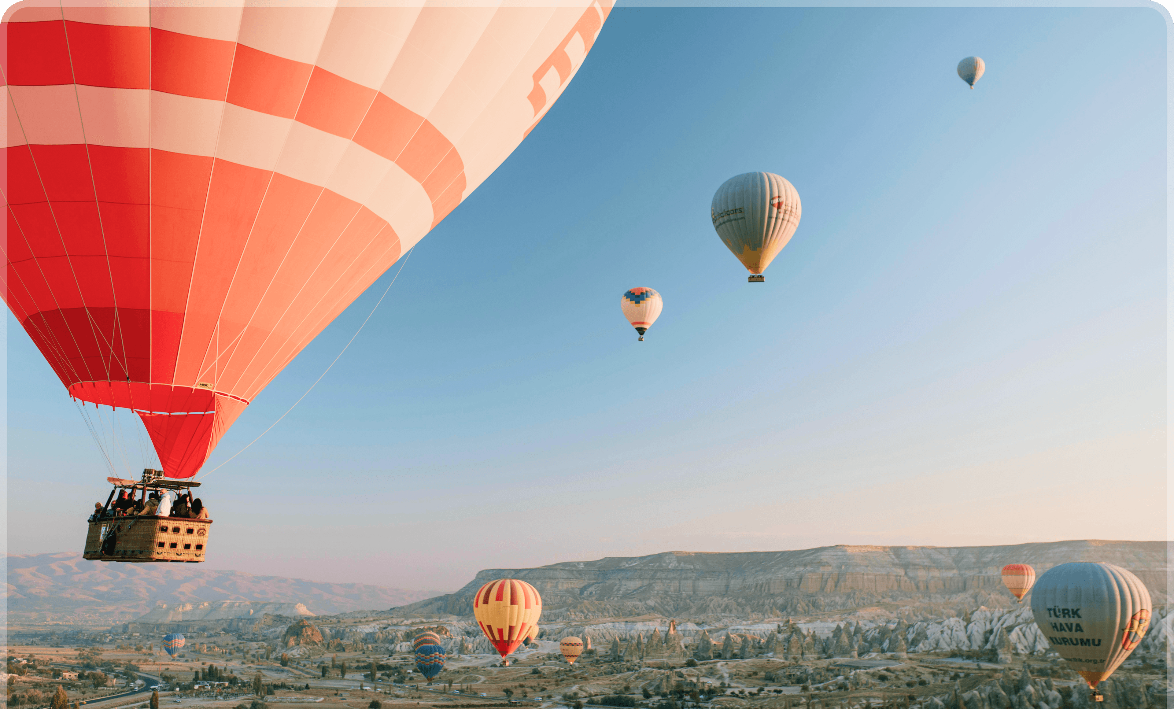 Globos aerostáticos sobre un valle al amanecer